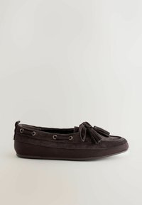 Mocassin en daim noir avec glands, détails en dentelle et semelle en caoutchouc, montré de profil sur un fond clair uni.