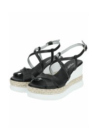 Sandalias de cuña de cuero negro con correas entrelazadas, plataforma texturizada blanca y ribete de yute; correa ajustable en el tobillo con una hebilla plateada.