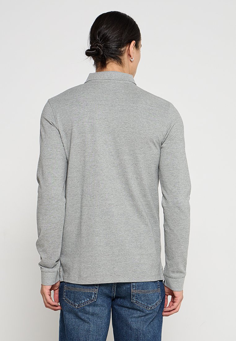 Polo-shirt à manches longues, gris clair, avec un col, fabriqué en tissu doux. Précise un ourlet droit et des poignets en côtes ; vue arrière présentée.