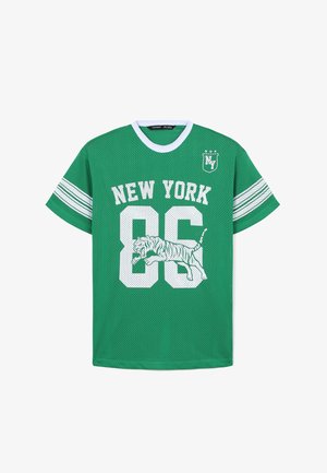 Zielona siatkowa koszulka z białym napisem "NEW YORK 86" oraz grafiką wskakującego tygrysa. Uzupełniona białymi paskowanymi rękawami i okrągłym dekoltem.