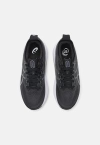 Zwarte sportschoenen met een gestructureerde bovenkant, voorzien van een grijs logo en veters, een witte middenzool en een ademend ontwerp.