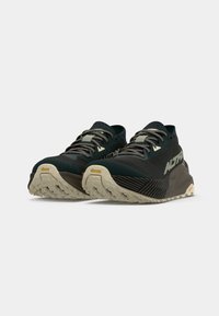 Black and dark green running shoes with a textured upper, prominent branding, and a beige Vibram sole. Features grey laces and cushioning design.