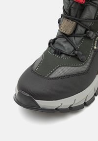 Botas de senderismo en negro y gris con una parte superior texturizada, punta reforzada, sistema de cordones y una suela resistente con acentos en contraste.