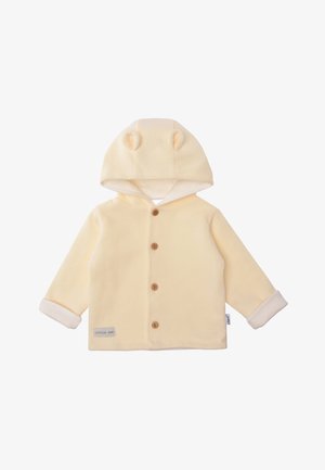Gelbe Kapuzenjacke aus weichem Stoff. Mit runden Ohren an der Kapuze, Holzknöpfen und weißen Bündchen. Das Etikett am Saum trägt die Aufschrift "Kleiner".