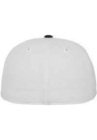 Hvid tætsiddende kasket med en rund krone, prydet med en sort knap på toppen. To ventilationshuller på hver side; glat stoftekstur.