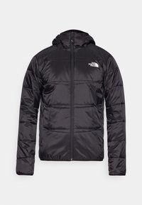 Svart dunjakke med hette, quiltet design, glidelås og North Face-logo på venstre bryst. Laget av lett, skinnende materiale.