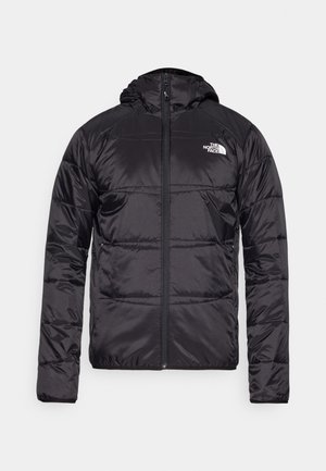 Chaqueta acolchada negra con capucha, diseño acolchado, cierre de cremallera y el logo de The North Face en el lado izquierdo del pecho. Fabricada con material ligero y brillante.