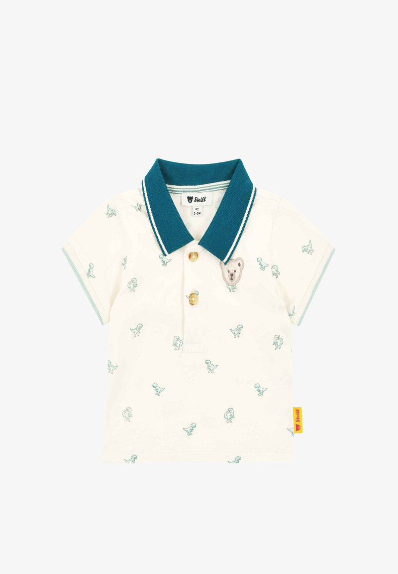 Polo en coton crème avec col vert sarcelle, orné de petits motifs de dinosaures et d'une applique d'ours sur la poitrine. Fermeture à trois boutons.