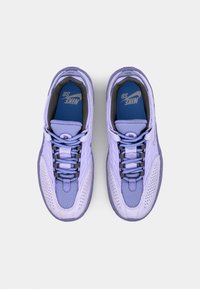 Nike sneakers viola con superiore in rete testurizzata, punta rinforzata e lacci grigi a contrasto. Presentano un collare imbottito e una soletta blu con logo.
