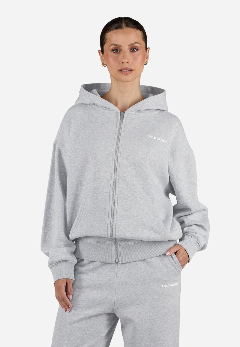 Felpa grigia con zip realizzata in tessuto morbido, dal taglio rilassato, dotata di cappuccio, tasche frontali e stampa del logo bianco sul petto.
