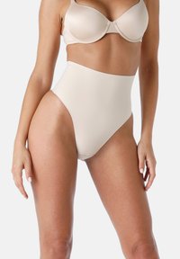 Shapewear alta vita di un beige chiaro con texture liscia e bordi curvi, progettata per un fit senza soluzione di continuità sul corpo.