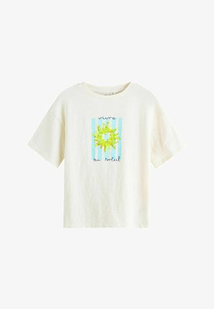 Maglietta bianca a maniche corte con righe verticali blu, una grafica di un sole giallo e testo francese "vivre au soleil" sul davanti.