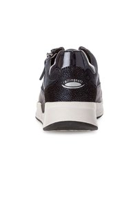 Black sneaker with a combination of suede and patent leather, rounded shape, light-colored sole, and metallic accents. Features a zipper closure.