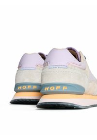 Baskets à lacets avec une tige en suède légère violette et beige, des accents bleus, et une semelle en caoutchouc texturée avec le logo "HOFF" sur le talon.