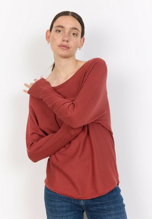 Rostfärgad, översized tröja med vid halsringning, långa ärmar och en textured finish, ihop med åtsittande blåjeans.
