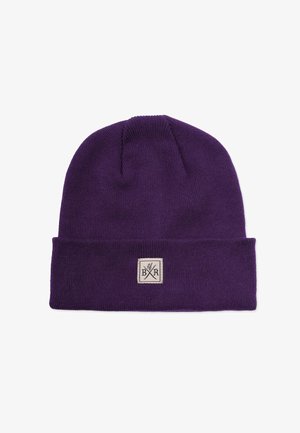 Lilla strikket hue med en foldet kant, prydet med et firkantet stofmærke med et logo. Blød tekstur og tætsiddende pasform.