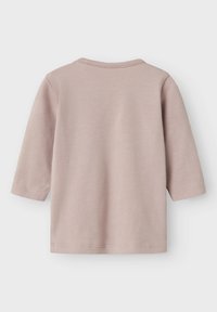 Camisa de manga larga de color rosa claro con cuello redondo, tela de algodón suave y dobladillos sencillos cosidos. Sin patrones ni adornos.