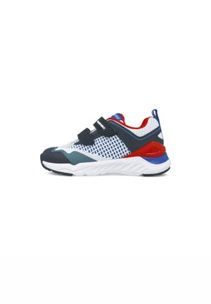 Zapatilla deportiva con una parte superior de malla blanca y acentos en azul y rojo, dos correas de velcro negras y una suela texturizada para mayor agarre.