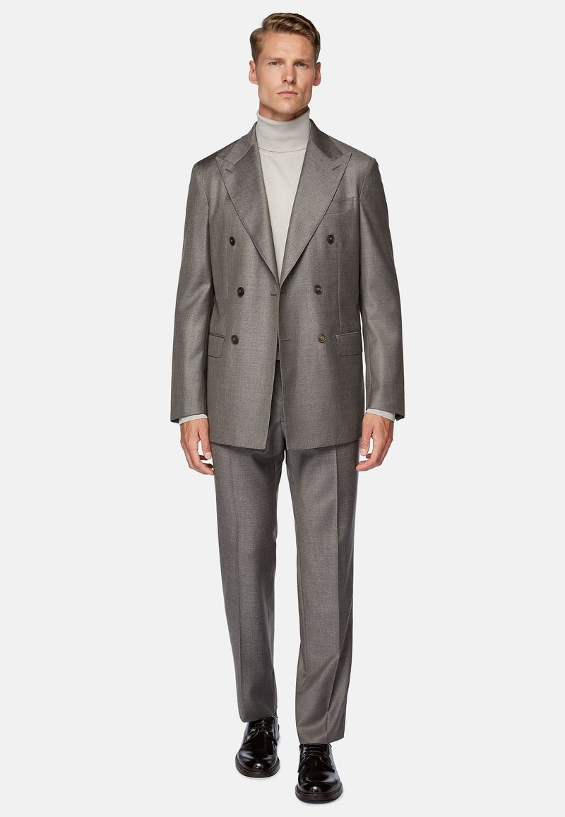 Gray double-breasted suit with a textured finish, paired with a light turtleneck. Black dress shoes complete the formal look.