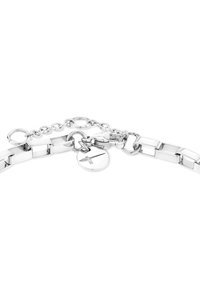Bracciale in metallo argentato con segmenti piatti e collegati, un charm rotondo e una chiusura a catena con un gancio sicuro. Finitura lucidata.