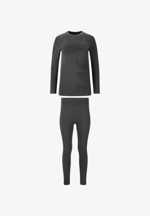 Zwart athleisure set met een lange mouwen top en strakke leggings. Glad materiaal met textuuraccenten en een prominent logo op de top.