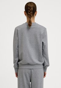 Grijze sweatshirt met een ronde hals, geribbelde manchetten en tailleband. Textuurstof, losse pasvorm, gecombineerd met bijpassende grijze broek.