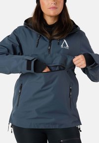 Vattentät marinblå anorakjacka med justerbar huva, dragkedjeförsedd framficka, sidodragkedjor och logotyp på bröstet. Lättvikts, mjuk textur.