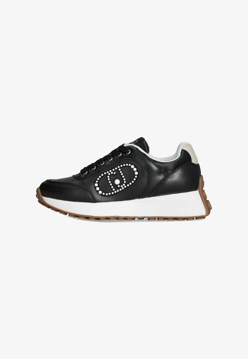 Sneaker in pelle nera con accenti bianchi, borchie decorative in un motivo ovale, chiusura con lacci e suola in gomma rigata marrone.