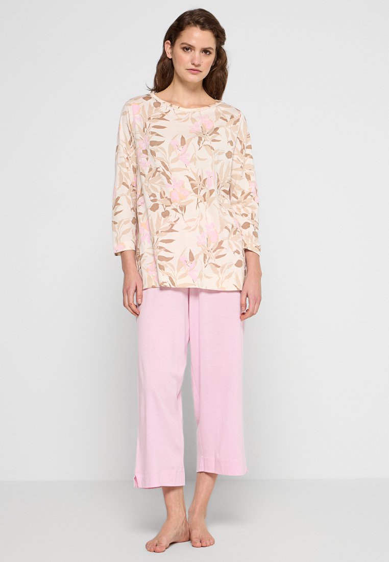 Beige top met bloemenpatroon, met roze bloemen en bruine bladeren. Gecombineerd met lichtroze wijde broek. Zachte stof, relaxte pasvorm.