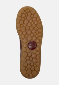 Brown sneaker sole with circular, textured grip pattern, featuring the label "Camper" and size "42" highlighted in red.