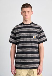 Sort stribet t-shirt med en lomme, der har vandrette striber i forskellige nuancer og et lille orange logo på lommen. Lavet af bomuldsmateriale.