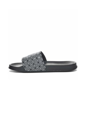 Sandal in gomma nera con una tracolla testurizzata che presenta un motivo floreale bianco. Suola piatta e finitura liscia e opaca.