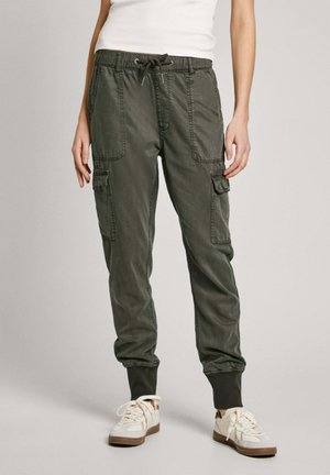 Slim Fit olivgrüne Cargohosen mit elastischen Bündchen und Kordelzugbund, getragen mit weißen Sneakern und weißem Tanktop.