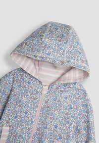 Chaqueta con capucha floral en colores pastel con flores azules y rosas. Forro interior a rayas en rosa y detalle de cierre con cremallera. Textura de tela suave.
