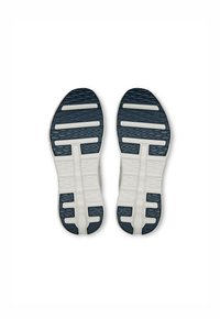 Schuhsohlen in Weiß und Marineblau, mit einem strukturierten Muster aus Rillen und Blocks für Traktion und Stabilität.