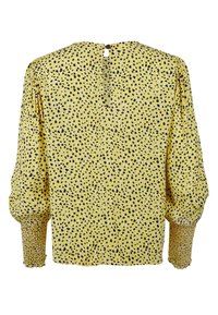 Blusa gialla con motivo maculato nero e bianco, maniche lunghe a sbuffo, polsini arricciati e chiusura a chiave sul retro. Tessuto leggero.