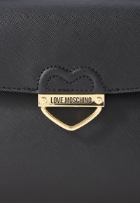 Black synthetic handbag featuring a textured surface, heart-shaped stitching, and a gold-tone hardware clasp with "LOVE MOSCHINO" engraving.
