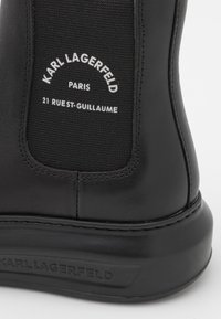 Zwarte leren Karl Lagerfeld laars met elastisch paneel, voorzien van witte merktext en een geperst logo op de zool.