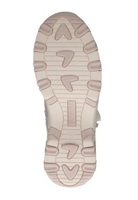 Suela de zapatilla beige claro con goma texturizada, que presenta un patrón en zigzag y tacos en forma de flecha para mayor agarre. Nombre de la marca "CAPRICE" visible.