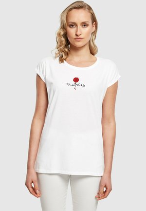 Weißes Baumwoll-T-Shirt mit umgeschlagenen Ärmeln, das ein gesticktes rotes Rosendesign und den Text "Frida Kahlo" darunter zeigt. Einfacher und lockerer Schnitt.