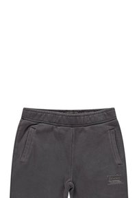 Grijze joggingbroek met elastische tailleband, twee zijzakken en een bedrukt label op de dij. Gemaakt van een zachte, comfortabele stof.