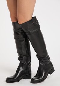 Schwarze Overknee-Stiefel aus glänzendem Leder, mit einem Reißverschluss an der Seite, einem lässigen Oberdesign und einem niedrigen Blockabsatz.