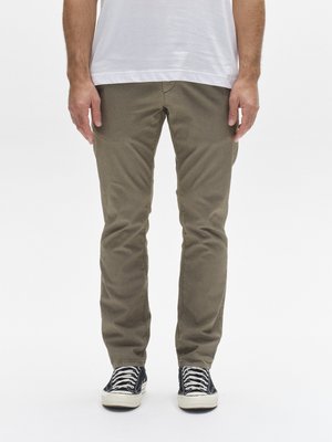 Pantalones de algodón verde oliva con un ajuste entallado, que presentan una textura suave y un sutil patrón de pana, combinados con zapatillas negras.