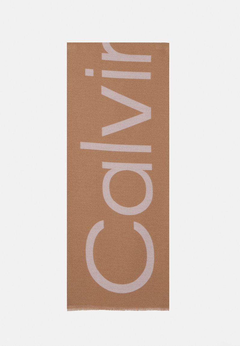 Écharpe rectangulaire marron avec de grandes lettres pâles formant verticalement le mot « Calvin » sur le tissu.