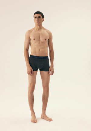 Herren-Boxershorts in Marineblau mit einem Punktmuster. Hergestellt aus dehnbarem Stoff, mit einem bequemen Gummibündchen und dem Logo 'HENDERSON'.