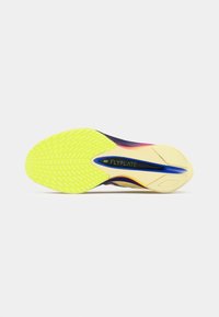 Semelle d'une chaussure de course Nike Flyplate avec une bande de roulement avant jaune vif et une plaque au milieu du pied bleue sur un fond blanc.
