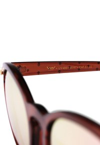 Hnědé želvovinové sluneční brýle s lesklým povrchem. Kulaté čočky, zlaté akcenty na rámu a vyryté detaily UV400 a CAT.3.