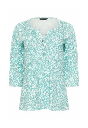 Lichtblauwe blouse met een wit bloemenpatroon, driekwart mouwen, ronde halslijn en vier decoratieve knopen aan de voorkant.