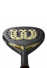 Wilsonpaddle med en svart texturerad yta, guldlogotyp och detaljer, flera perforeringar och ett svart grepphandtag.