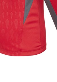 T-shirt de sport rouge avec une texture à motif en losange, présentant des accents gris et une finition en tissu lisse. Il a des ourlets cousus pour la durabilité.